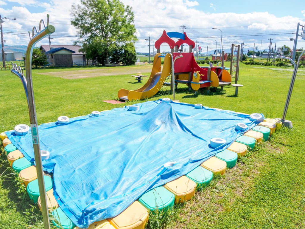 シートをかぶせた砂場と遊具