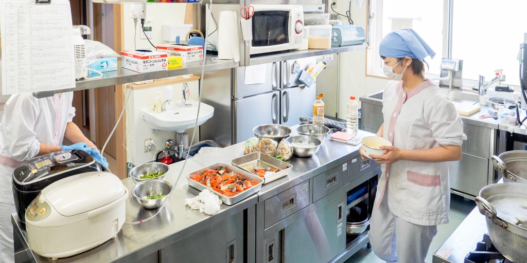 厨房で調理する栄養士と調理員