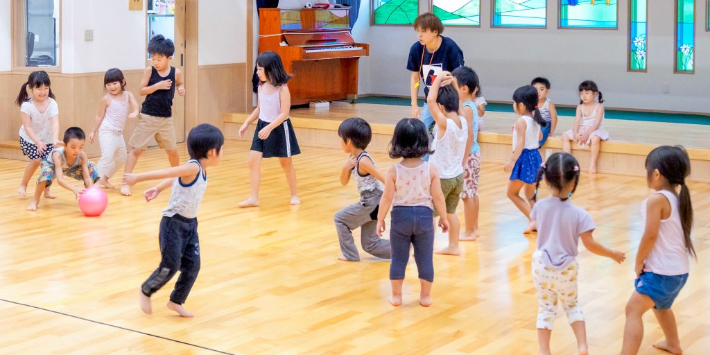 ホールでドッジボールをするこどもたち