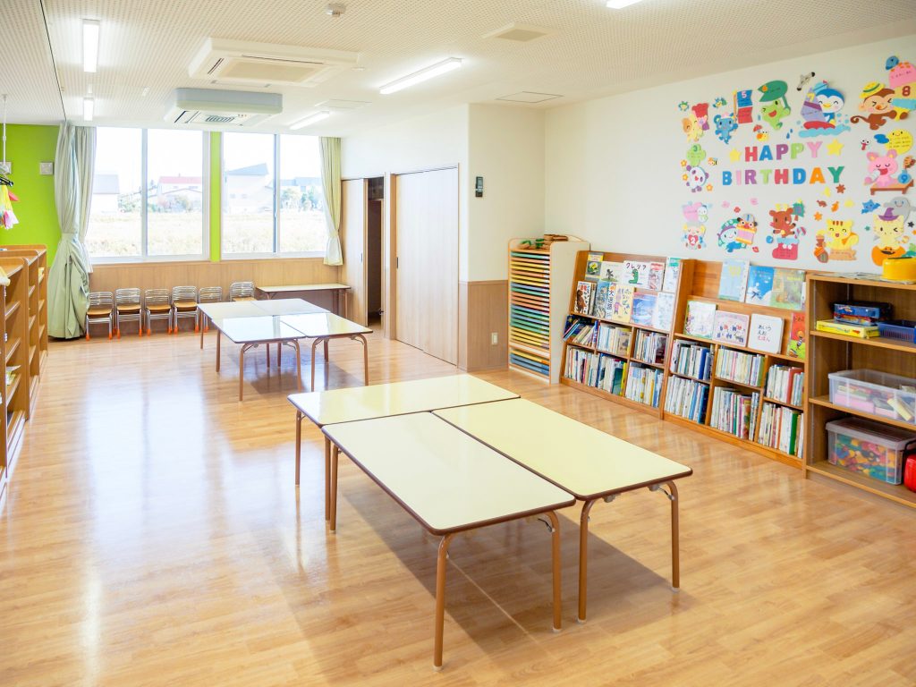 テーブルが並べられた保育室の右半分