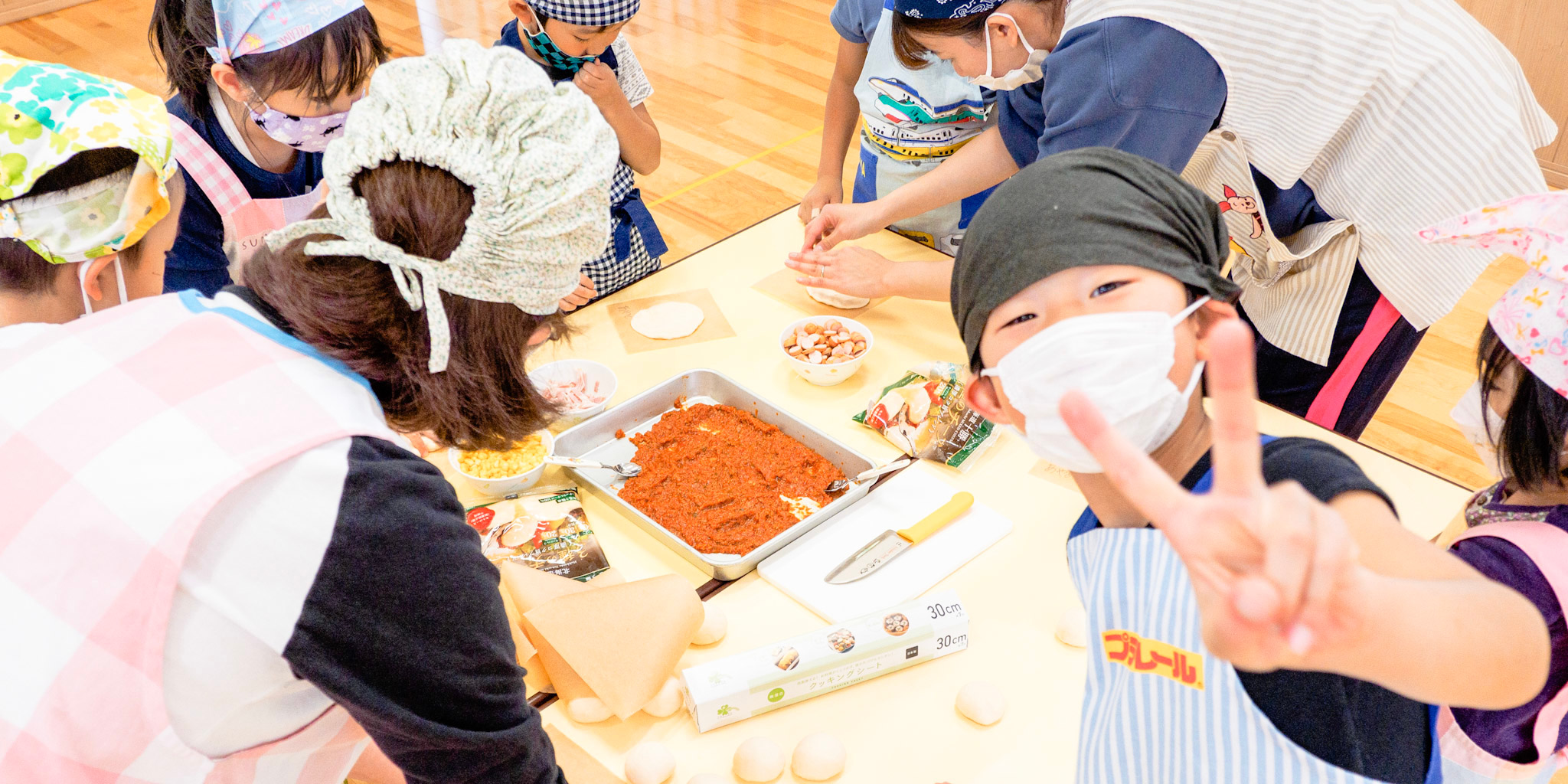 クッキング保育中の保育士と園児