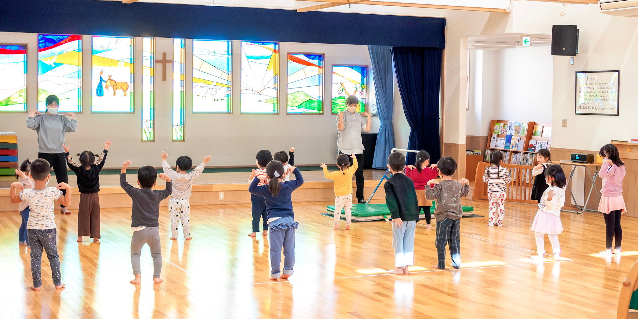 ホールでラジオ体操をする園児たち